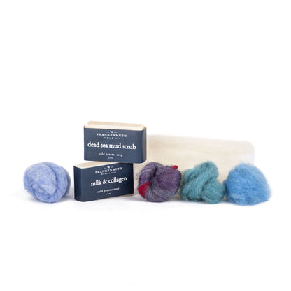 Two bars of soap with wool roving on a white background
