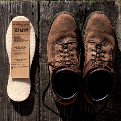 Wool shoe inserts beside brown leather boots